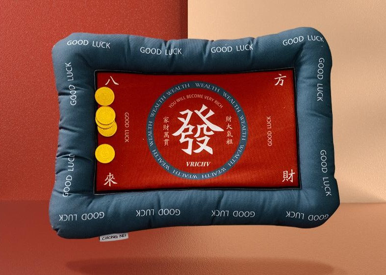 Mahjong-themed rectangular cushion featuring a red center with a white Chinese character symbolizing prosperity, gold coin illustrations, and a padded dark blue border printed with "Good Luck."