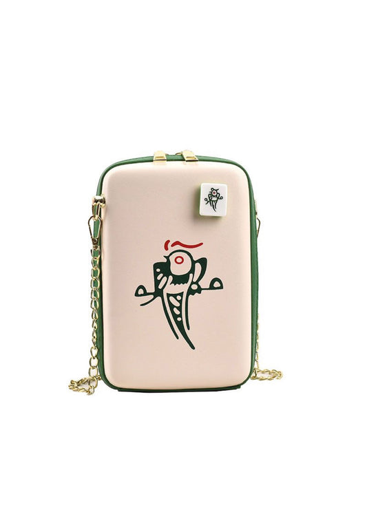 Mahjong-inspired crossbody bag featuring a beige exterior, green trim, gold chain strap, and a colorful green and red One Bamboo mahjong tile design with a bird illustration.