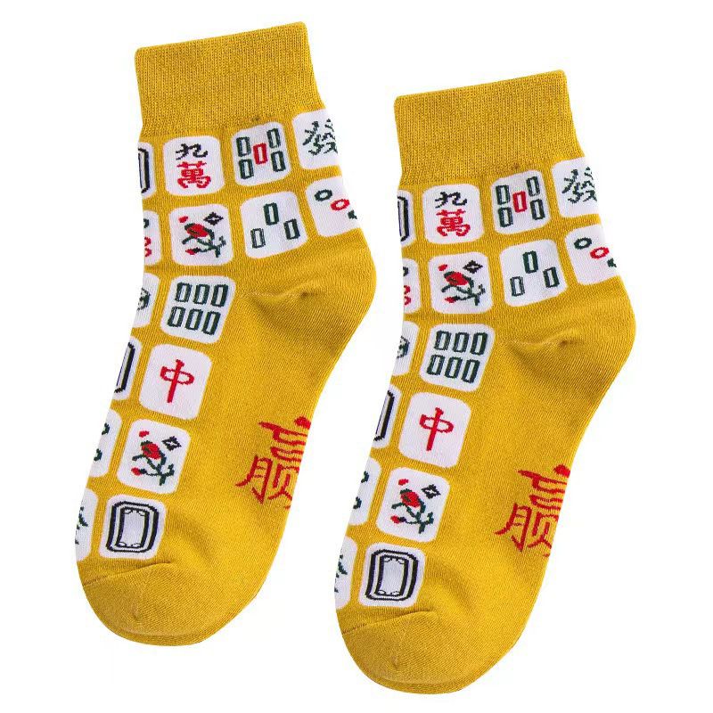 Pair of mustard yellow mahjong-themed crew socks featuring colorful mahjong tile designs in red, green, black, and white.